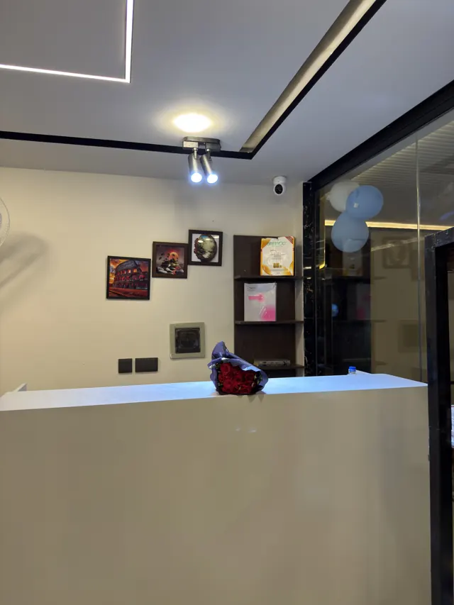 The front desk with framed pictures on the wall