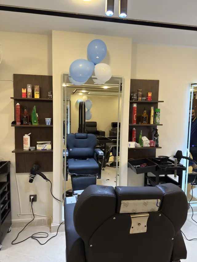 A barber station: chair, lit mirror and shelves of products